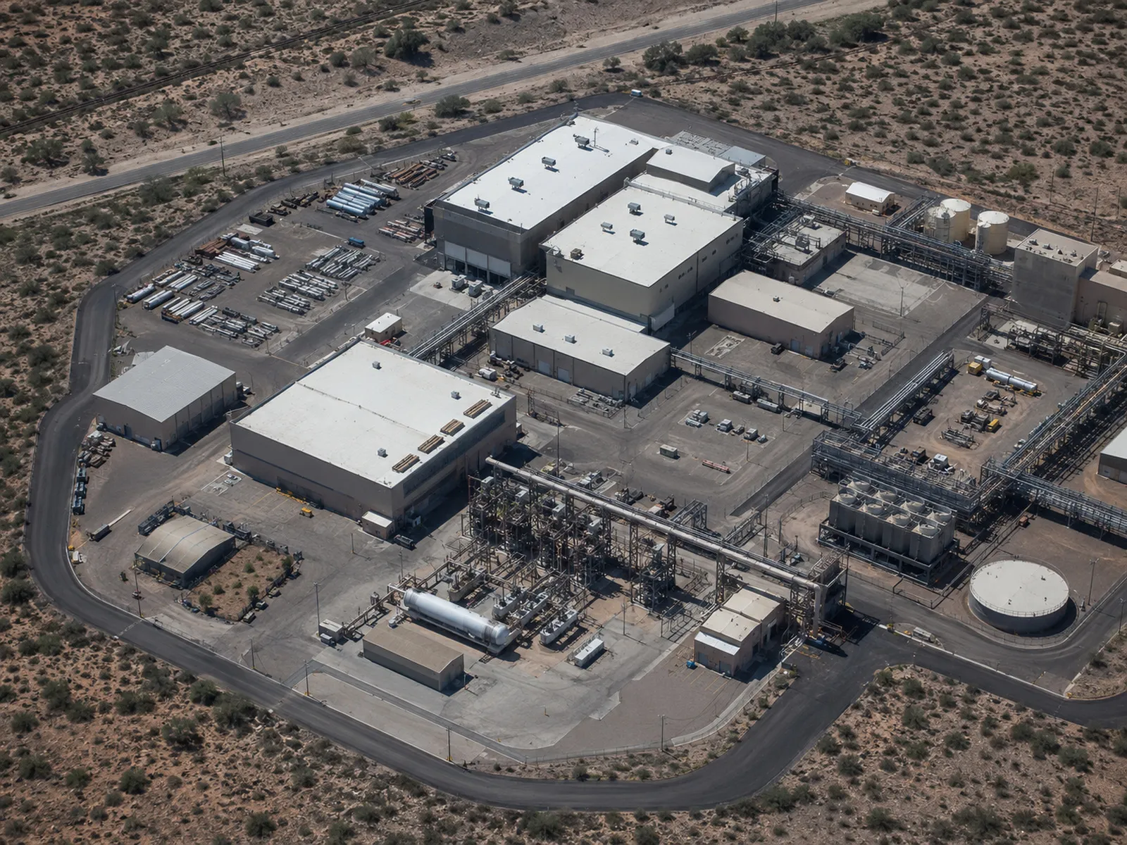Industrial facility exterior with visible facades, rooftop equipment, and yard areas.