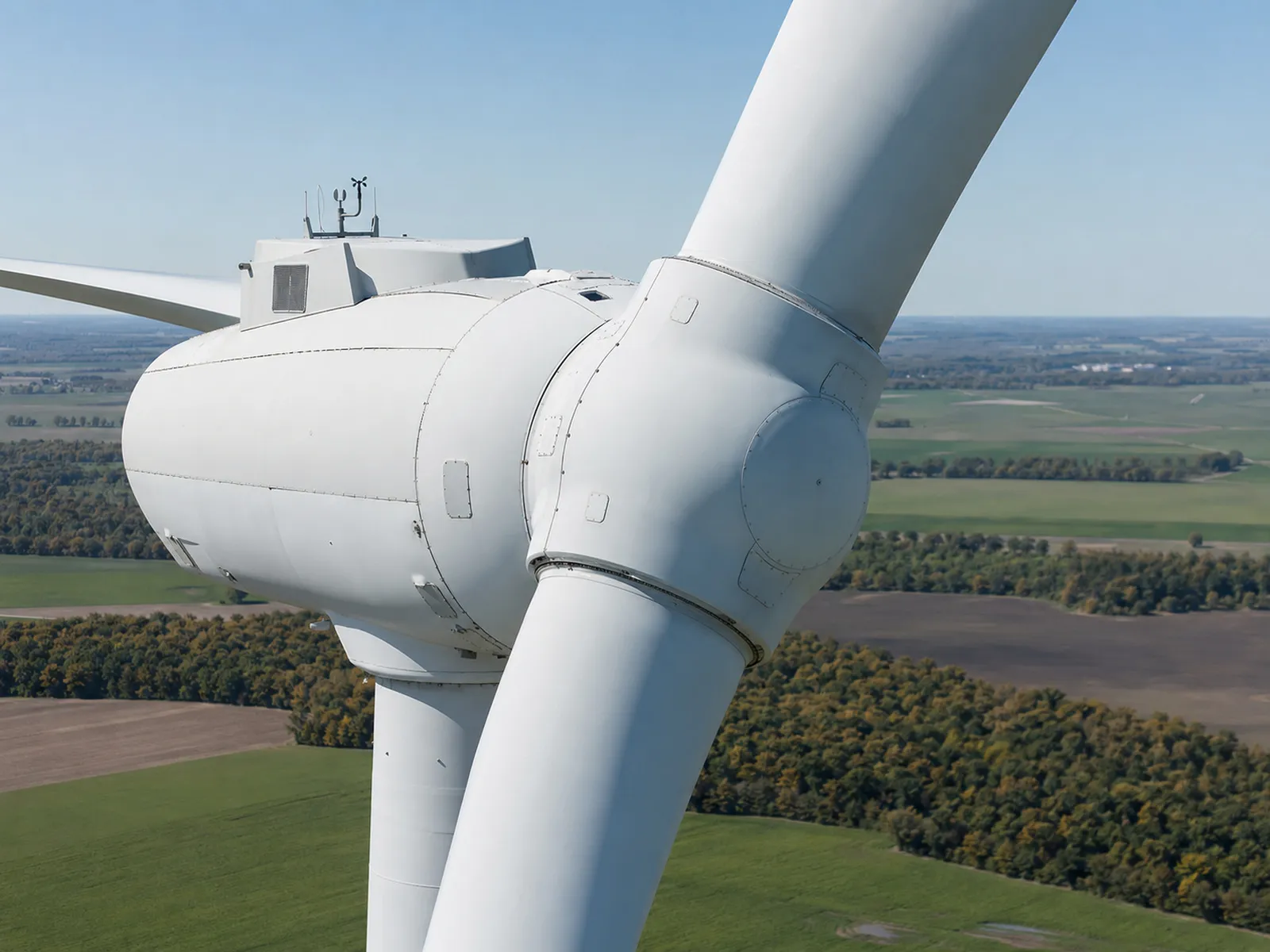 Wind turbine exterior from an elevated aerial position; turbine fills the frame.